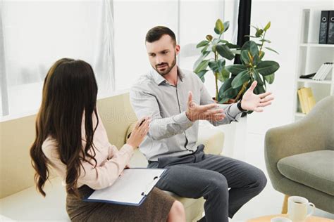 Psychiatrist With Clipboard Having Consultation With Male Patient Stock