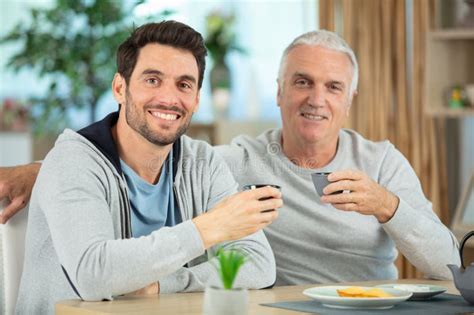 Son And Senior Father Sitting On Stairs Indoors At Home Stock Photo Image Of Flat Mature