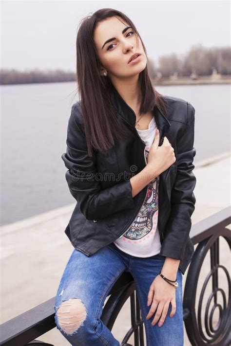 Beautiful Brunette Woman In Black Leather Jacket Walking On The Stock