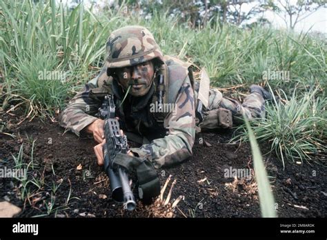 A Marine Armed With An M16a2 Rifle Equipped With An M203 Grenade