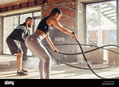 Caucasian Fit Couple Exercising With Battle Ropes At Gym Woman And Man