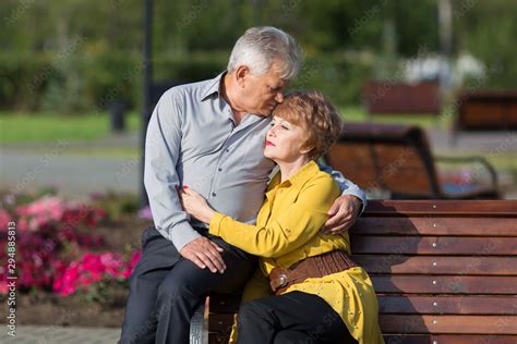 Mature Lovers Hug Tightly On A Bench In A City Park A Married Couple Of Pensioners On A Bench