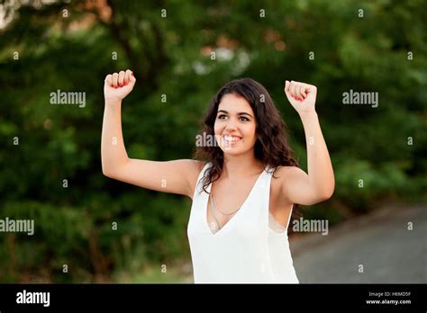 Beautiful Brunette Girl Celebrating Something In The Park Wiht Many Plants Of Background Stock