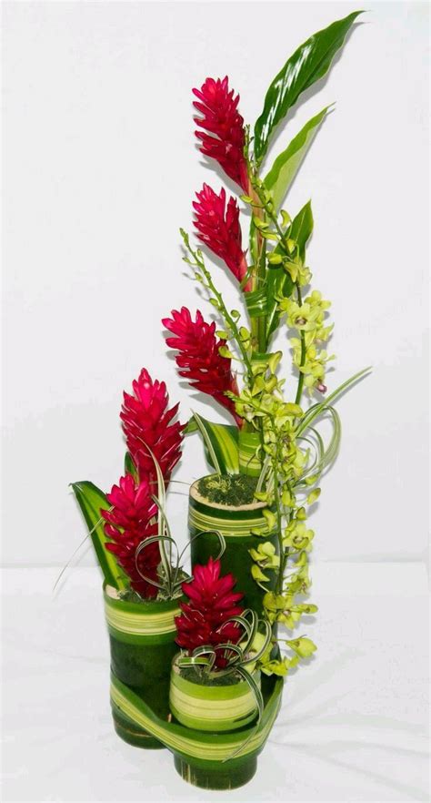 Three Green Vases With Red Flowers In Them