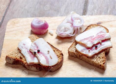 Bocadillo De La Manteca De Cerdo Con Pan Negro Y Cebollas En Un Tablero