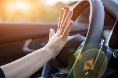 Mão aperta a buzina no volante de um carro moderno sem rosto Foto Premium