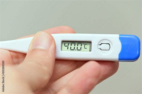 Hand Holding A Thermometer With A High Fever Temperature Of More Than