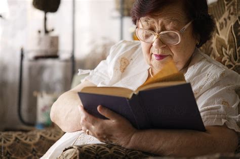 Senior Woman Reading A Book By Stocksy Contributor Ilya Stocksy