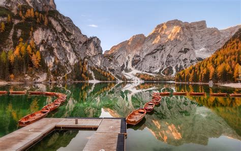 Pomost i szereg łodzi zacumowanych na jeziorze Pragser Wildsee