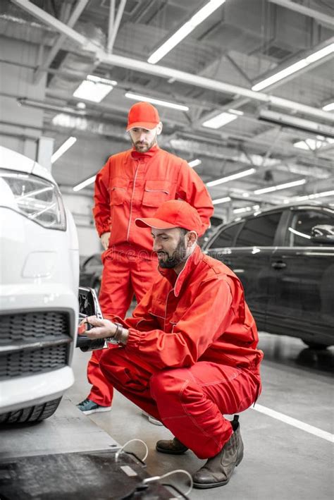 Auto Mechanics Making Wheel Alignment At The Car Service Stock Image