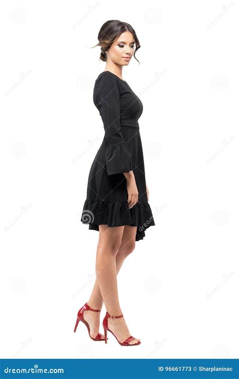 Side View Of Young Woman In Black Dress Standing And Looking Down