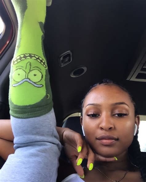 A Woman Sitting In The Back Seat Of A Car With Her Leg Up And Green Nail Polish