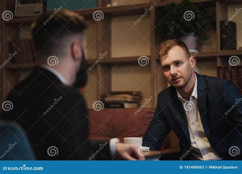 Two Men In Suits Sit In A Restaurant A Business Meeting Men Drink