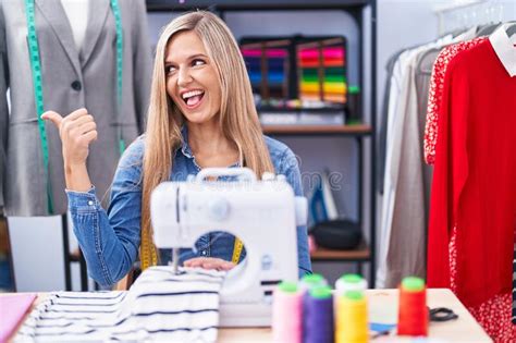 Blonde Woman Dressmaker Designer Using Sew Machine Smiling With Happy