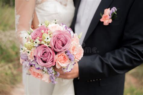 Huwelijkspaar Die De Bruid Die Een Boeket Van Bloemen In Haar Hand