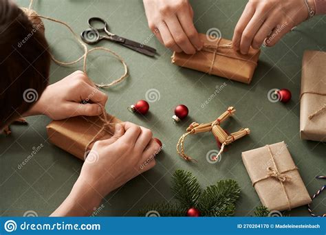 Hands Wrapping Christmas Presents In Ecological Recycled Paper Zero