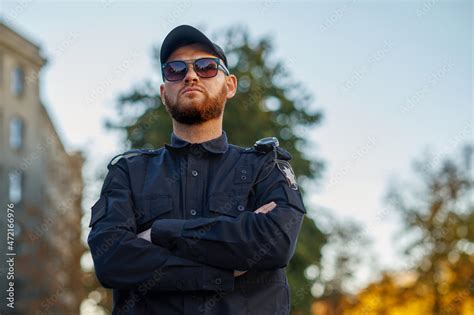 Police officer poses in uniform and sunglasses Stock Photo | Adobe Stock