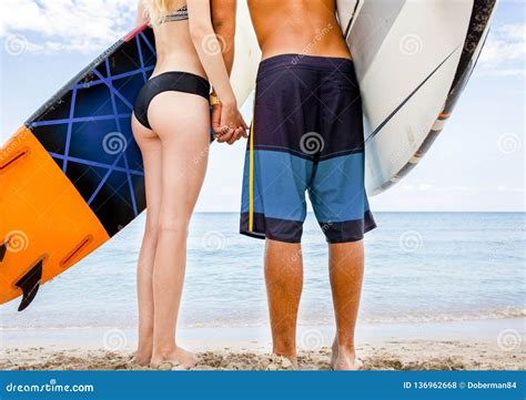 Surfers At The Beach Smiling Couple Of Surfers Walking On The Beach