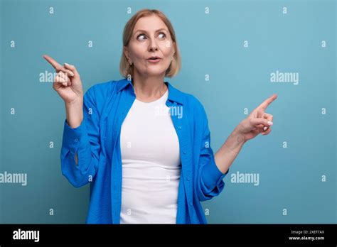 Surprised Blond Mature Woman In Disbelief On Blue Background With