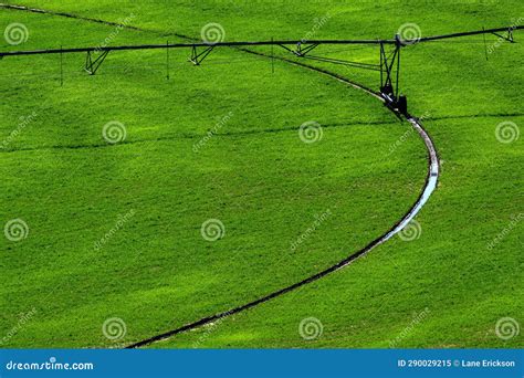 Irrigation Pivot In Lush Green Field With Circle Tracks On Ground Stock