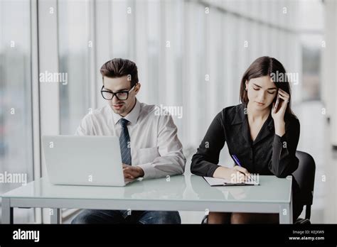 Handsome Business Man Working On Laptop While Business Woman Making