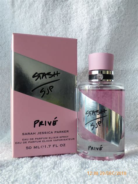 A Bottle Of Perfume Sitting Next To A Pink Box