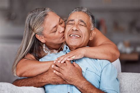 Happy Senior Couple Hug In Home Retirement Lifestyle Together In