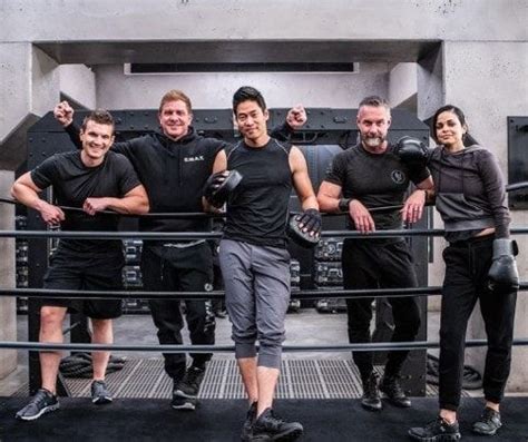 five people posing for a photo in front of a machine with their hands ...