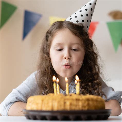 Une Fille Au Visage Mignon Souffle Des Bougies Sur Son Gâteau D