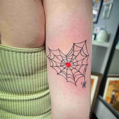 A Womans Arm With A Spider Web Tattoo On The Left Side Of Her Body