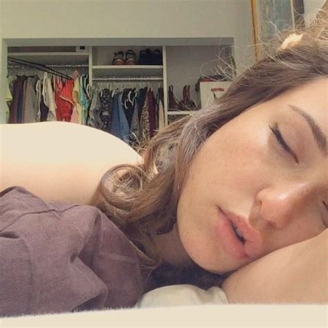 A Woman Laying In Bed With Her Eyes Closed