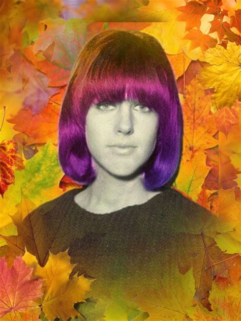 a woman with purple hair standing in front of leaves