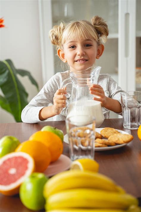 Petite Fille Joyeuse Assis La Table De La Cuisine La Maison Image