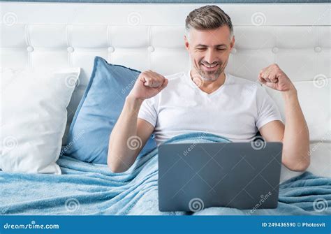 Happy Mature Man Working on Laptop in Bed Stock Photo - Image of ...