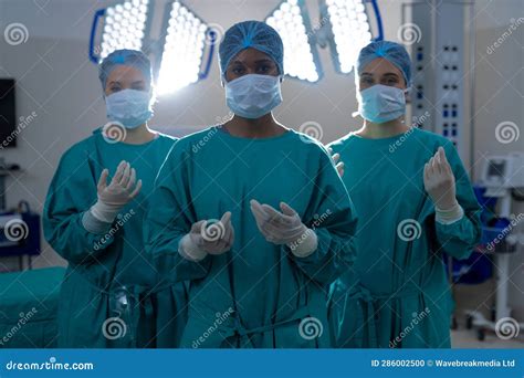 Portrait Of Diverse Female Surgeons Wearing Surgical Gowns In Operating