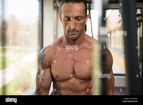 Muscular Mature Man Bodybuilder Doing Heavy Weight Exercise For Biceps