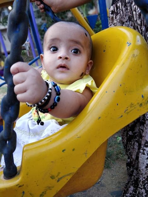 Premium Photo Cute Girl Sitting On Swing In Playground