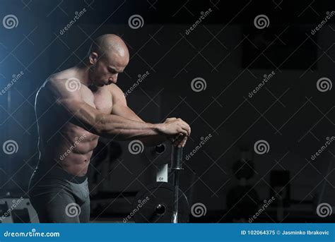 Homem Muscular Considerável Que Dobra Os Músculos No Gym Imagem de