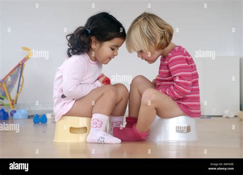 Two Toddler Girls Using A Potty Stock Photo Alamy