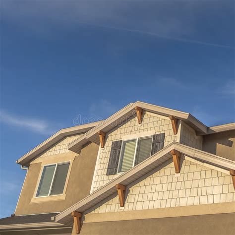 Square Home with Front Gable Roof and Dormers Against Vast Blue Sky with Clouds Stock Photo ...