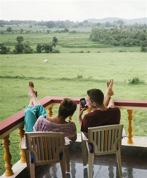 Couple With Smartphone On The Balcony By Stocksy Contributor Martin