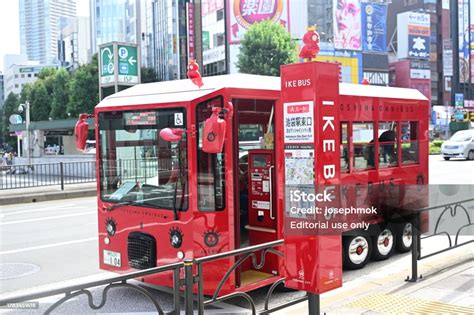 Brightred Electric Mini Travel Ike Bus And Bus Stops In Front Of