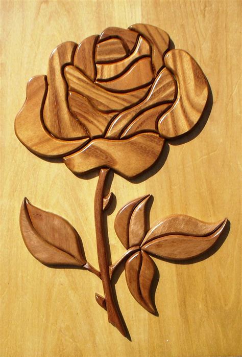 A Wooden Rose On A Table With Leaves And Stems Carved Into The Wood