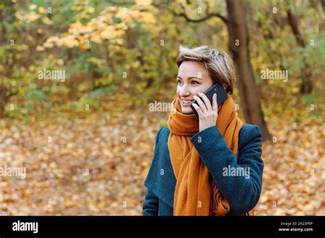 Short Haired Blonde Smiles As She Talks On The Phone In The Fall Outdoors Stock Photo Alamy