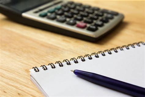 Cuaderno Con La Pluma Y Calculadora En La Tabla De Madera Foto De