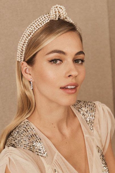 A Woman With Blonde Hair Wearing A Tiara And Pearls On It S Head