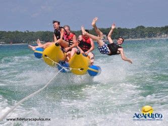 Four People Are Riding In The Air While Being Pulled On Water Skis By A