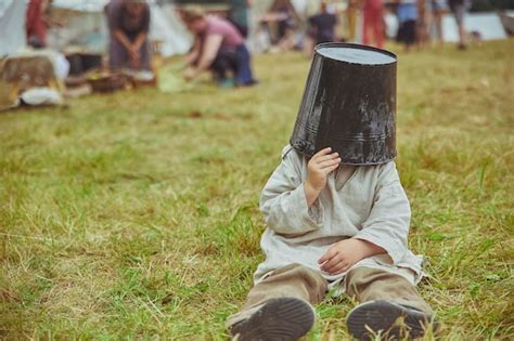 Premium Photo The Boy Fooling Around Puts A Bucket On His Head At