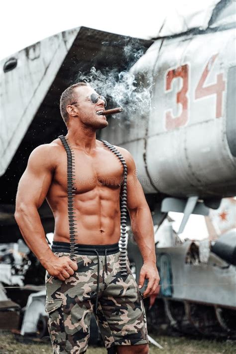 Strong Military Guy With Naked Torso Enjoying Cigar In Airport Stock