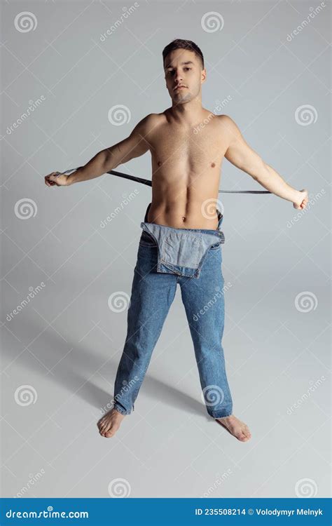 Retrato De Un Joven Afilado Hombre Sin Camisa En Jeans Posando En Un